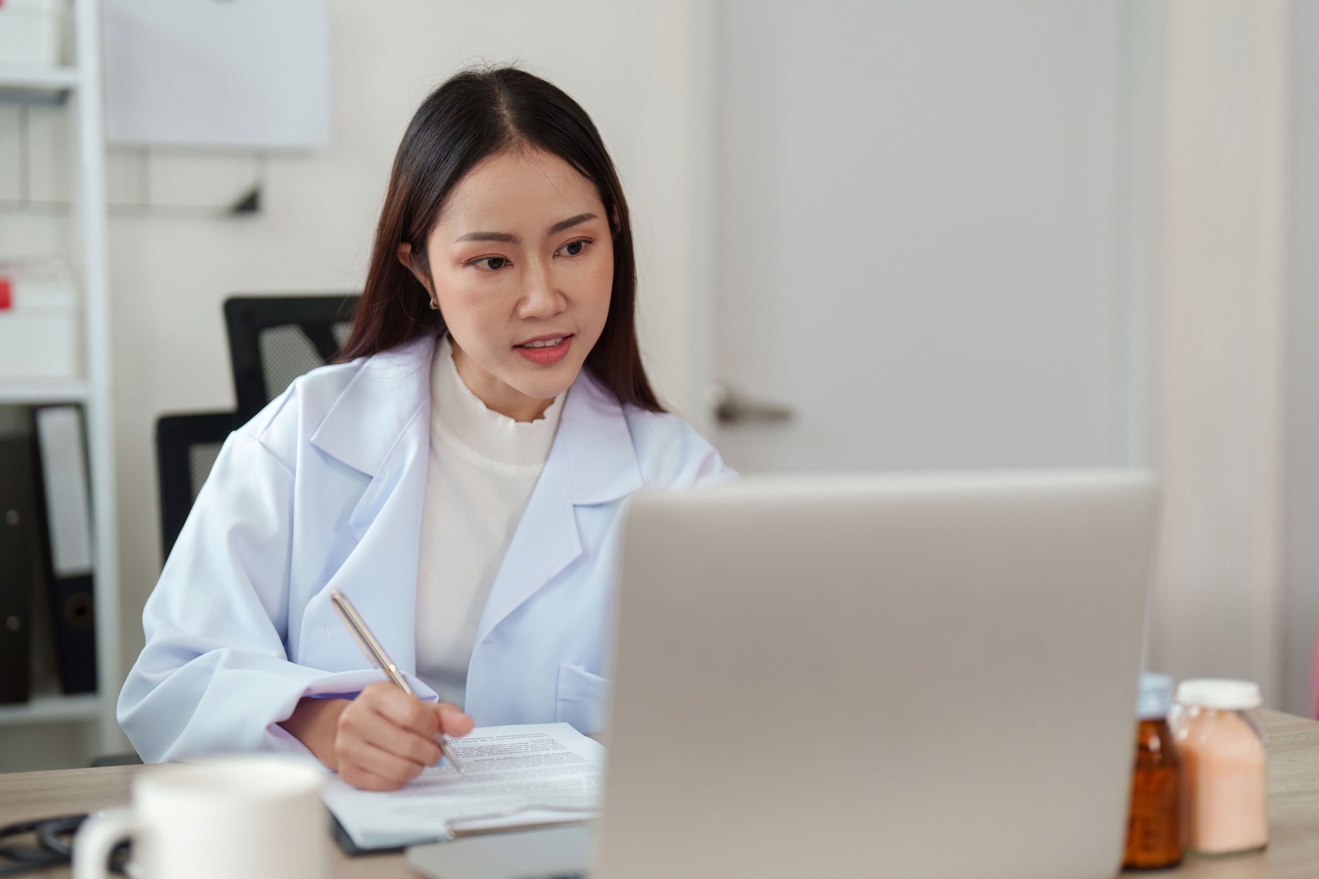 Patient Documentation and Virtual Engagement. A doctor expertly records patient notes during an online appointment.